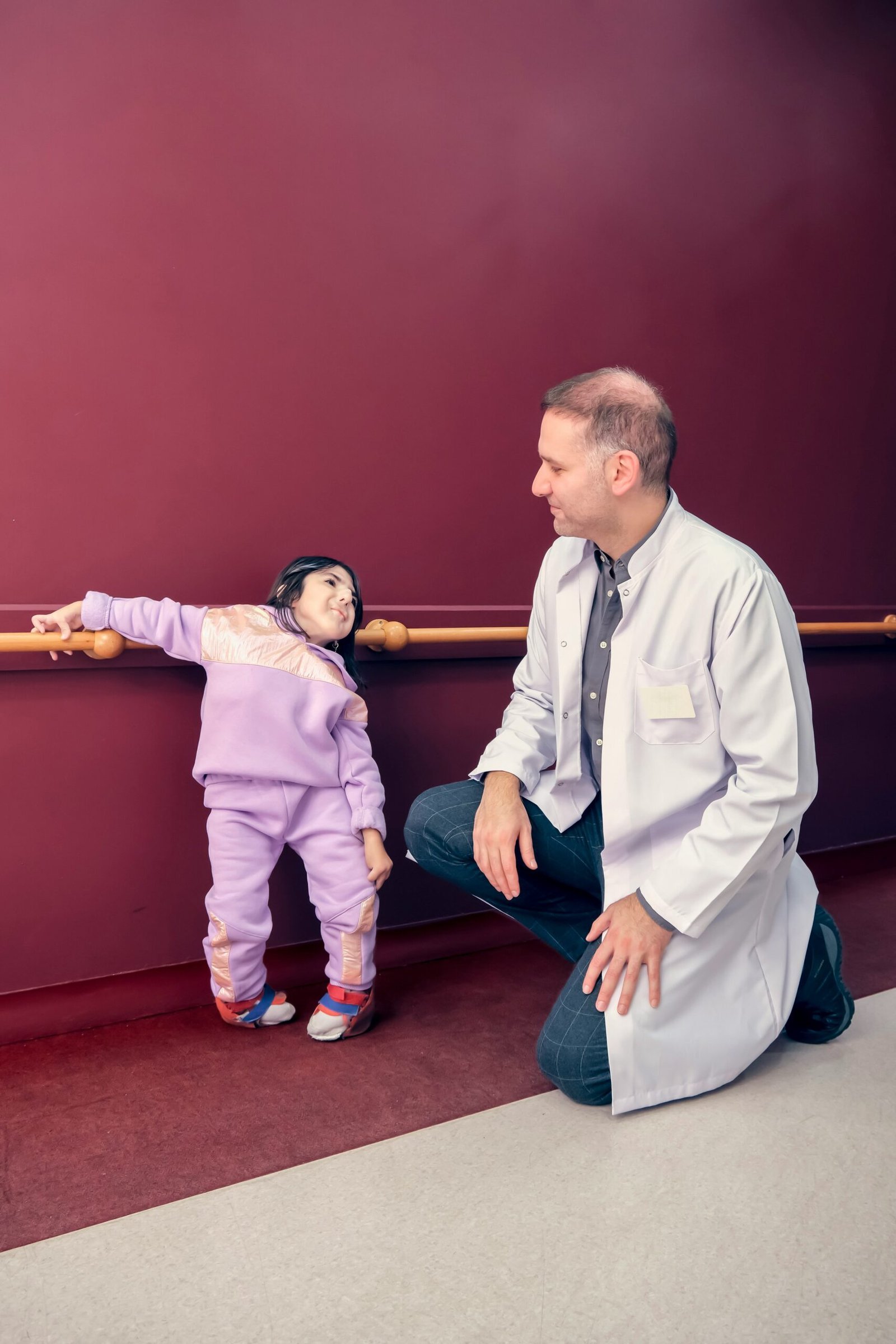 a man kneeling down next to a little girl